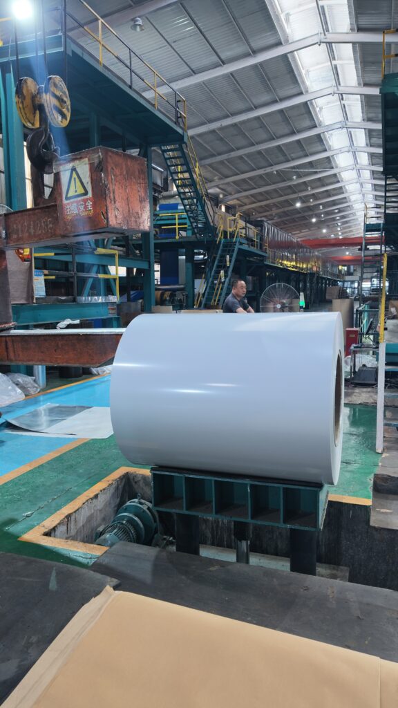 Large white finished PPGI coil placed on production line inside steel manufacturing factory